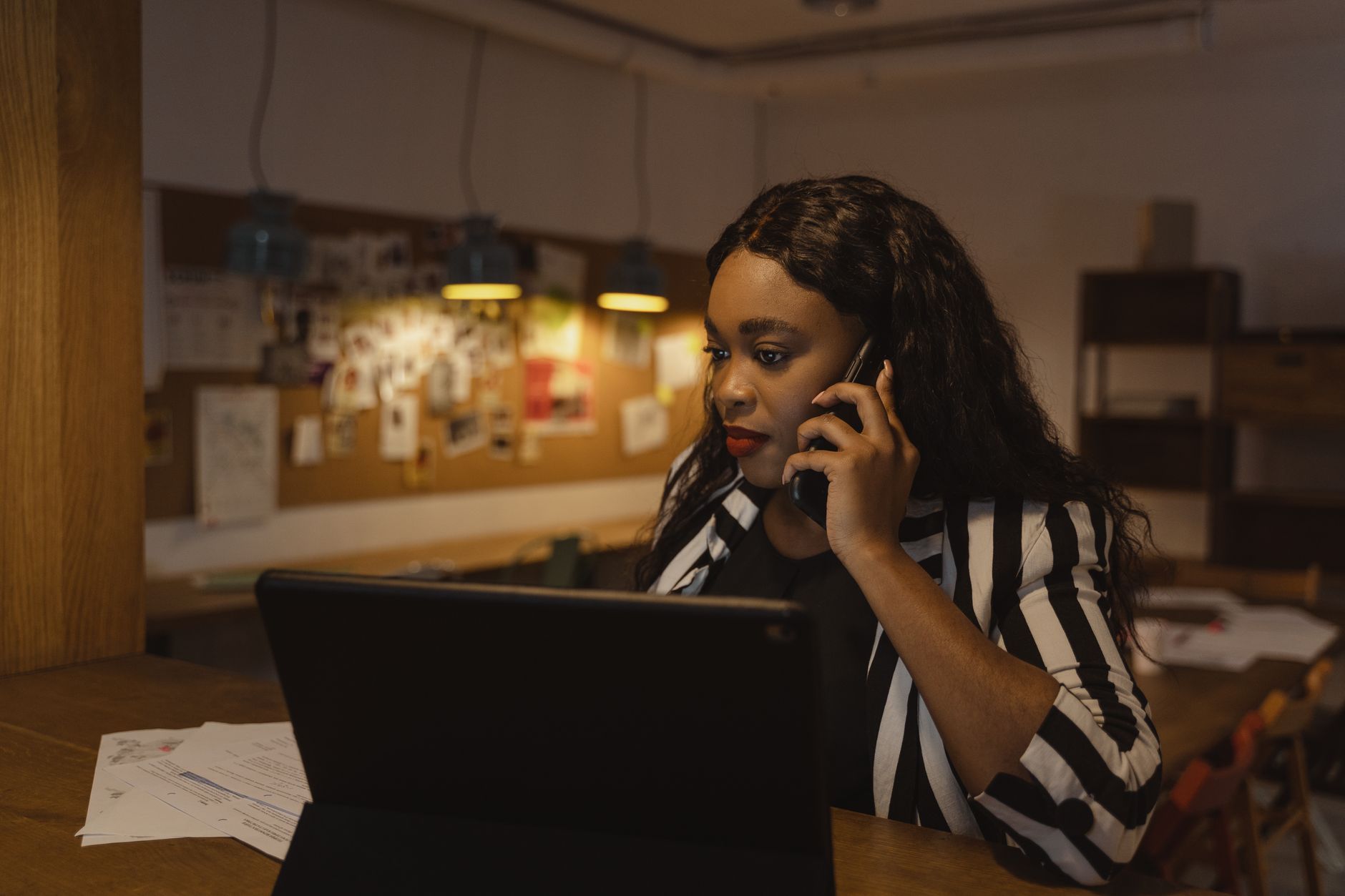 a woman in a striped blazer talking on the phone